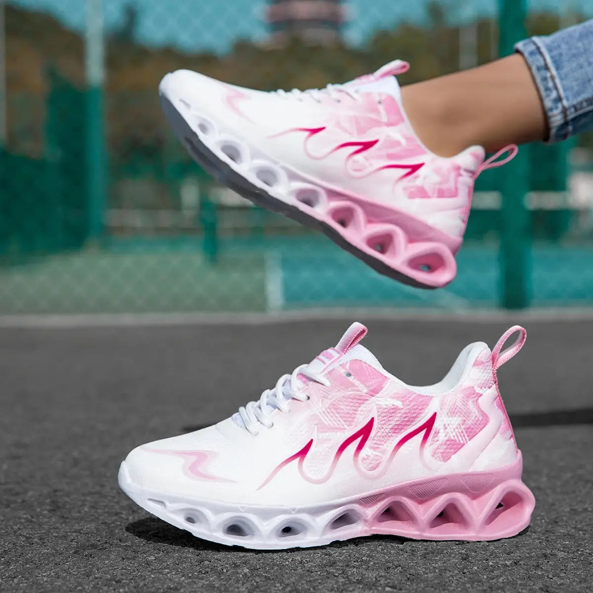 Lightweight women's sneakers in white and pink with breathable mesh and cushioned blade sole, ideal for running or daily use.