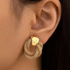 Golden round circle dangle earring on ear