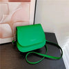 Green vintage PU leather crossbody bag on black table