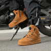 Brown leather biker shoes on a motorcycle background