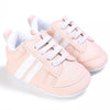 Peach baby sneakers with white stripes