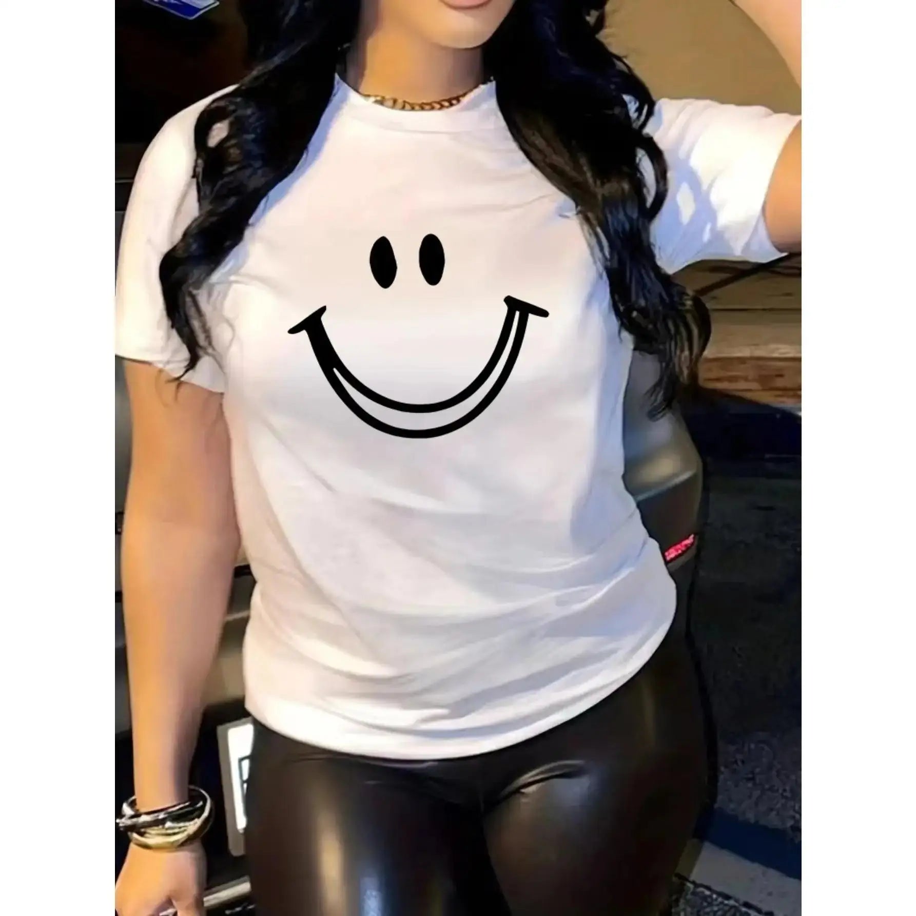 Women’s black T-shirt with joyful face print, styled casually with black leggings. Soft cotton crew neck ideal for casual wear.