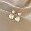 Square and round pearl stud earrings on satin