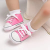 Pink baby sneakers with white laces