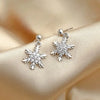 Silver snowflake dangle earrings on satin fabric