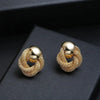 Golden round circle dangle earrings on black surface