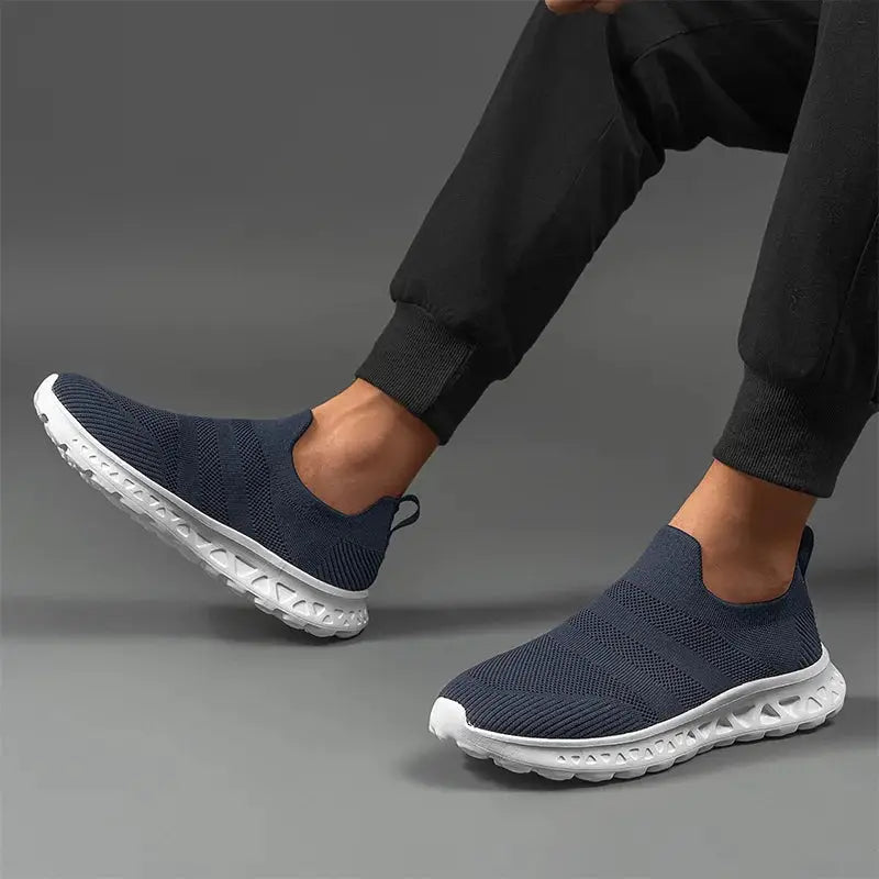 Lightweight navy men’s slip-on sneakers with breathable mesh upper and cushioned sole for running, walking, or everyday wear.