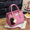 Pink faux leather handbag with pom-pom charms