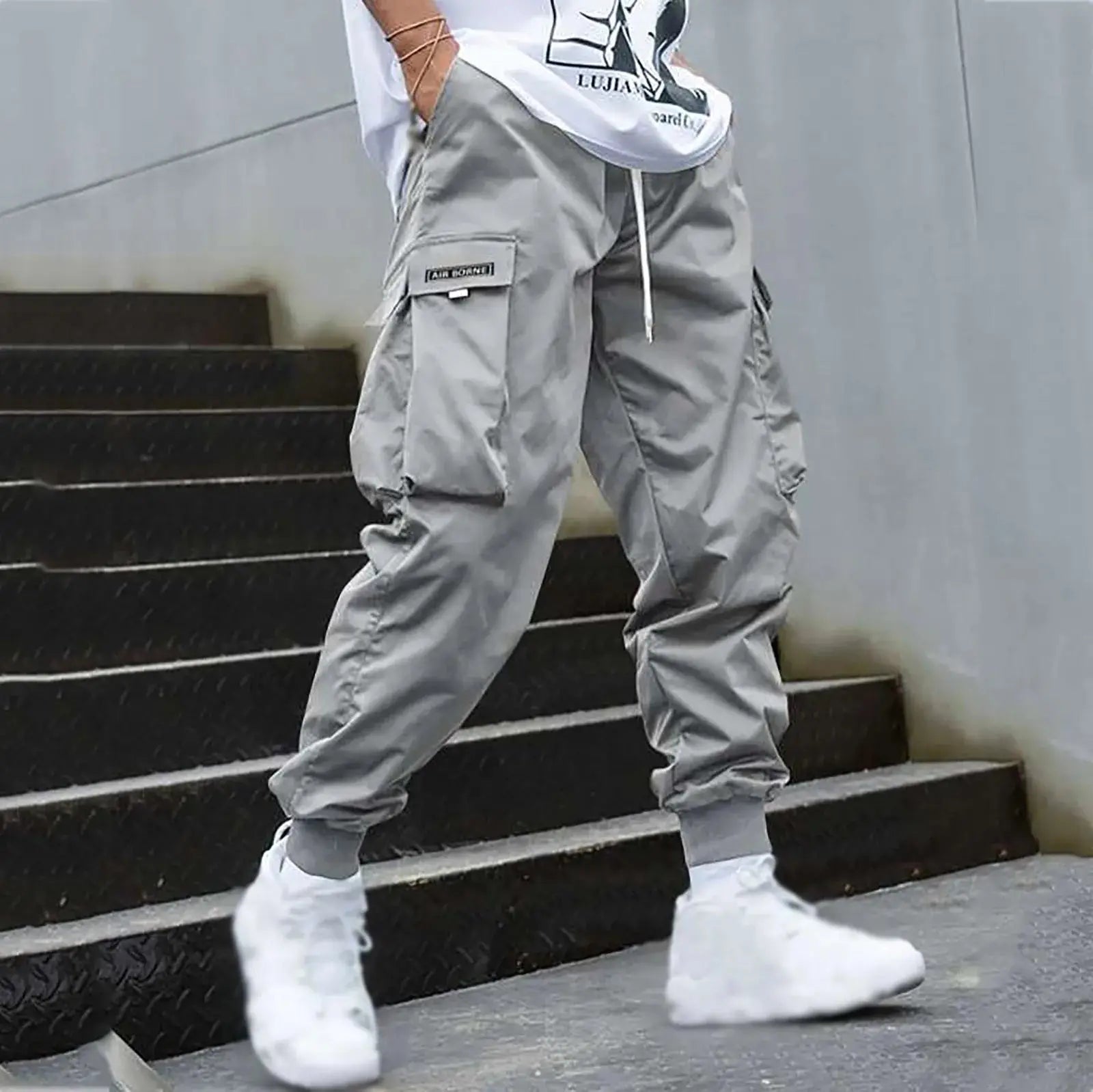 Light gray men’s casual cargo jogger pants with drawstring and utility pockets, offering a sleek look for urban streetwear or daily use.