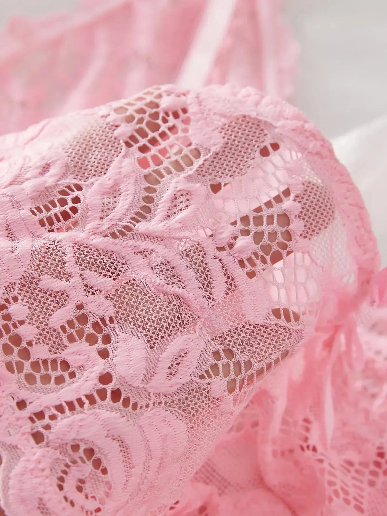 Close-up of intricate pink floral lace fabric from the women's V-neck sleepwear set, showcasing delicate texture and detail.