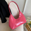 Glossy pink shoulder bag on white chair