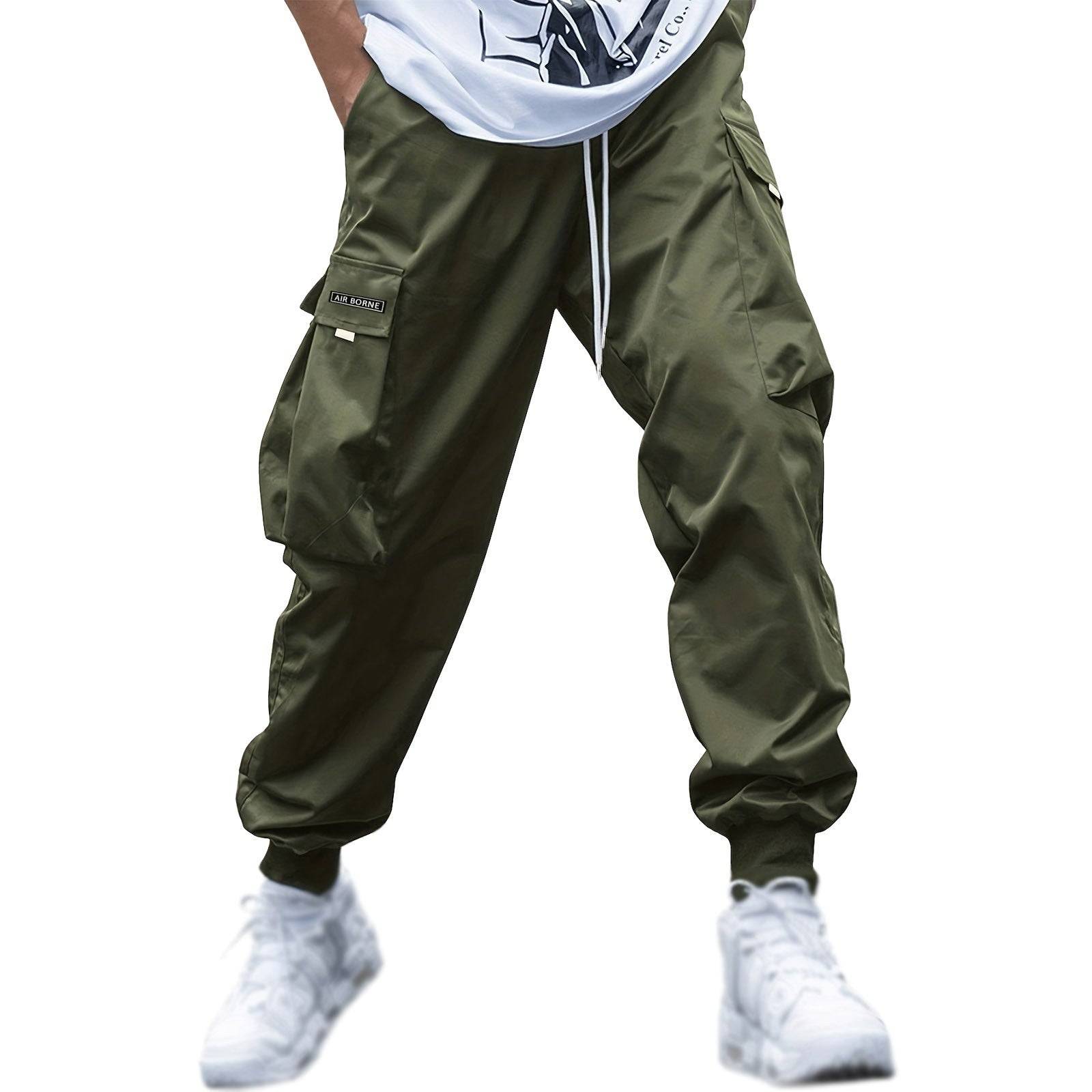 Army green men’s casual cargo jogger pants with drawstring and flap pockets, styled for urban streetwear or relaxed outings.