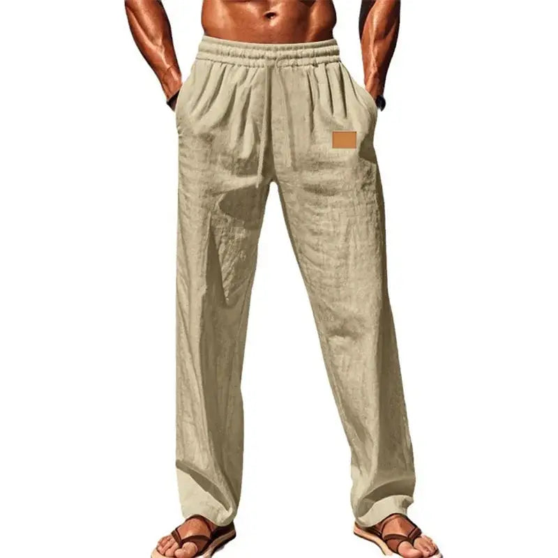 Beige men’s breathable drawstring pants with elastic waist and relaxed fit, styled for casual or summer wear with sandals.