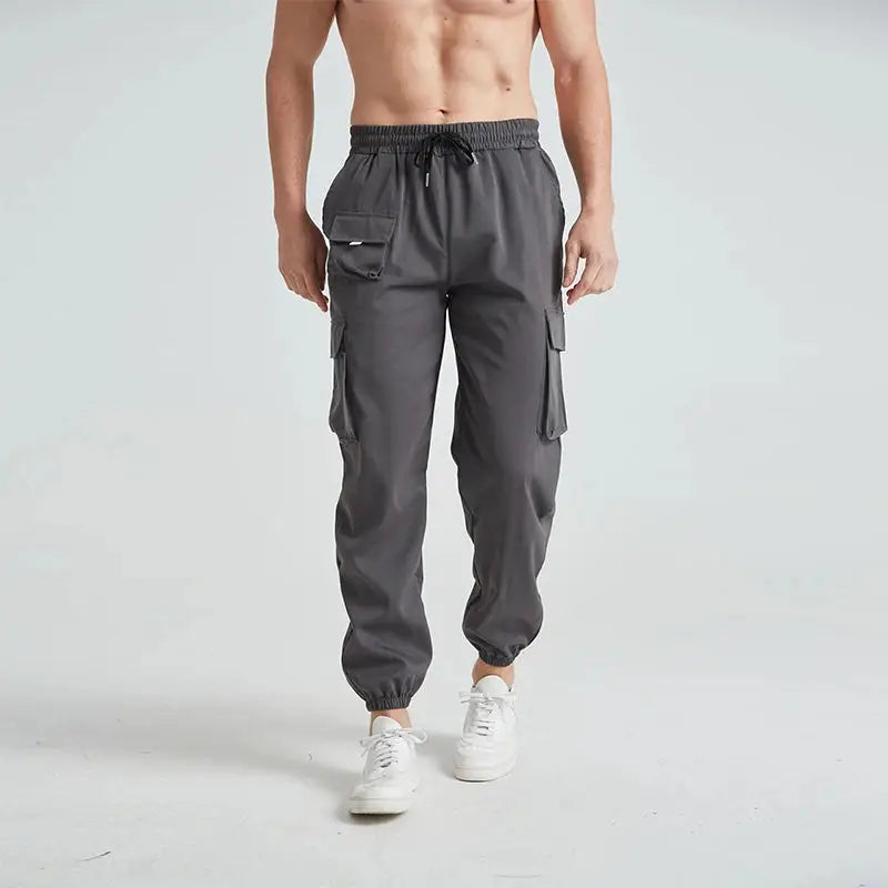 Gray men’s quick-dry cargo hiking pants with adjustable waistband and side pockets, designed for comfort and outdoor performance.