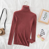 Rust women's turtleneck sweater on bed