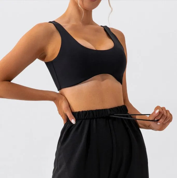 Black slim fit yoga bra, side view, styled with black joggers.