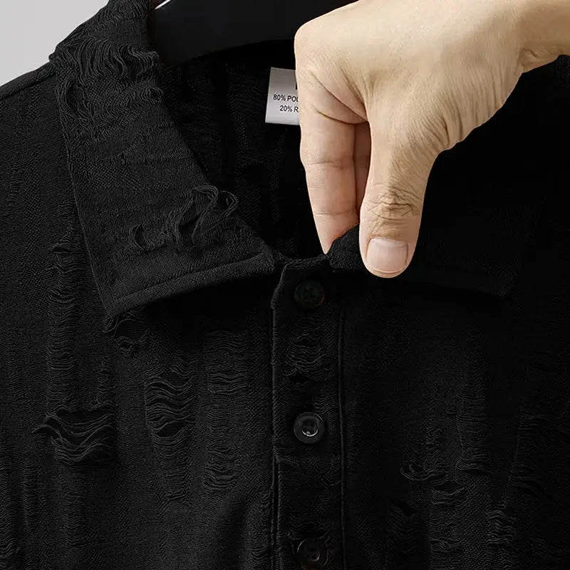 Hand holding collar of black men’s short sleeve T-shirt with buttoned V-neck and distressed texture, showcasing fabric detail.