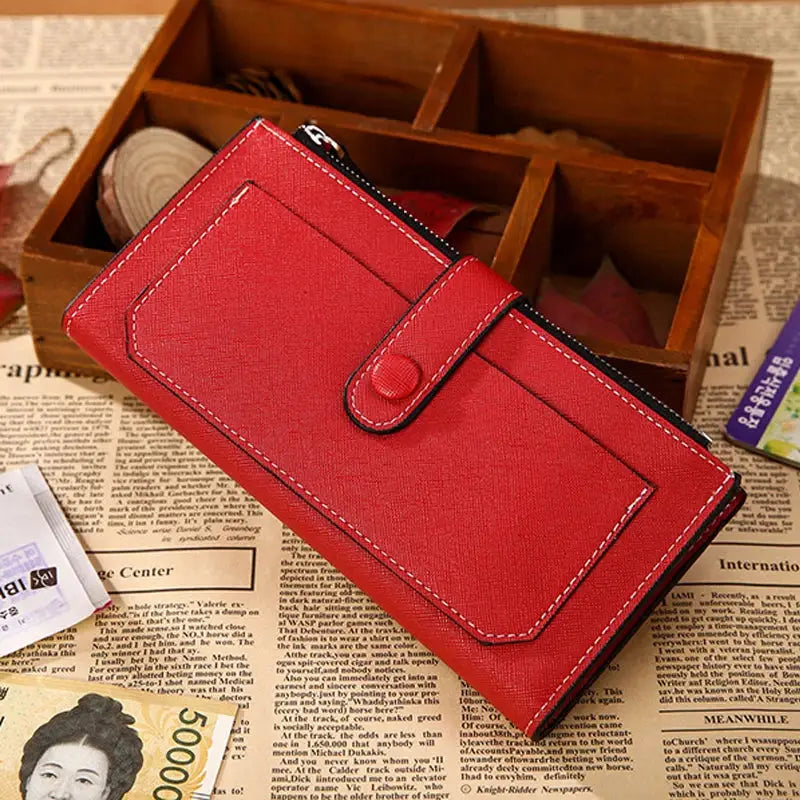 Red women's PU leather bifold long wallet with buckle strap and zippered pocket, displayed on a vintage newspaper layout.