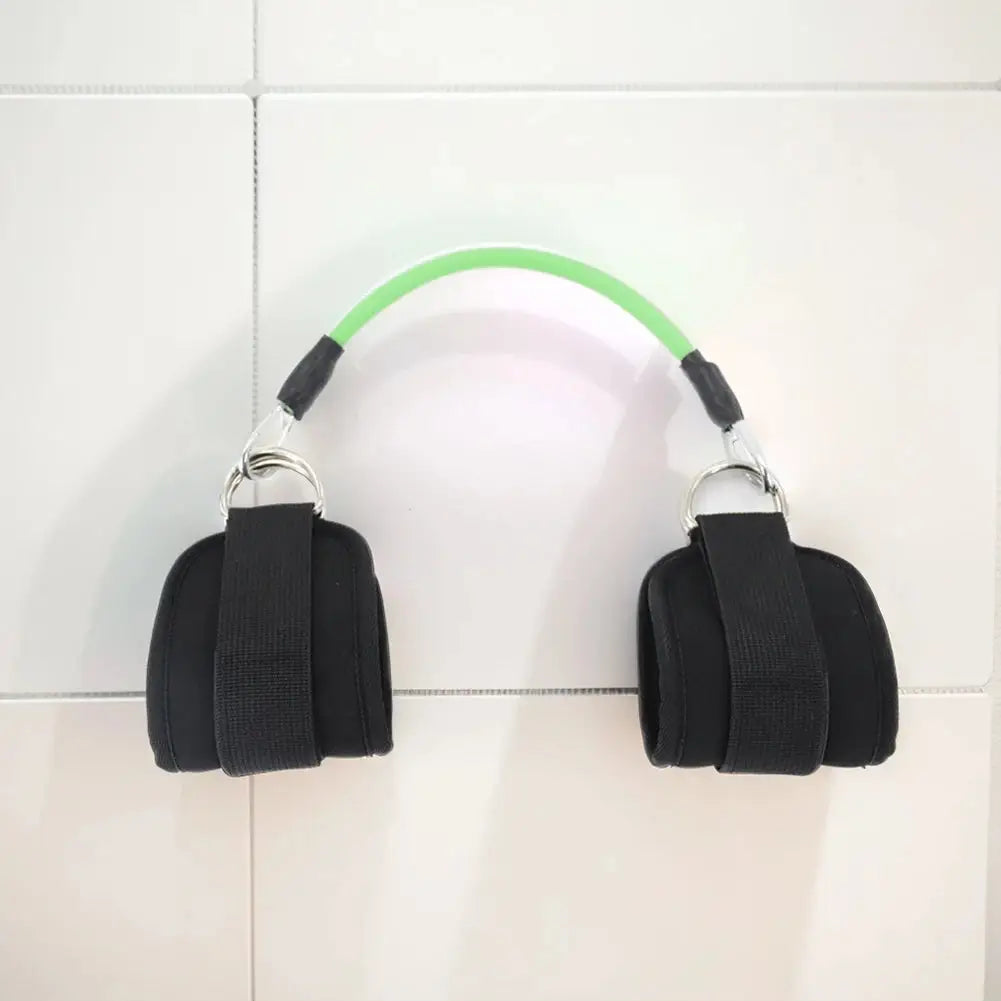 Green resistance band connected to two padded ankle straps, ideal for leg and hip strength training exercises at home or gym.