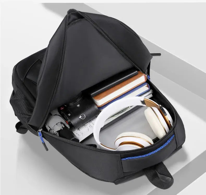 Interior of men’s waterproof Oxford backpack packed with books, headphones, and gadgets, perfect for school or business travel.