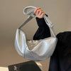 Silver shoulder bag held by person in black