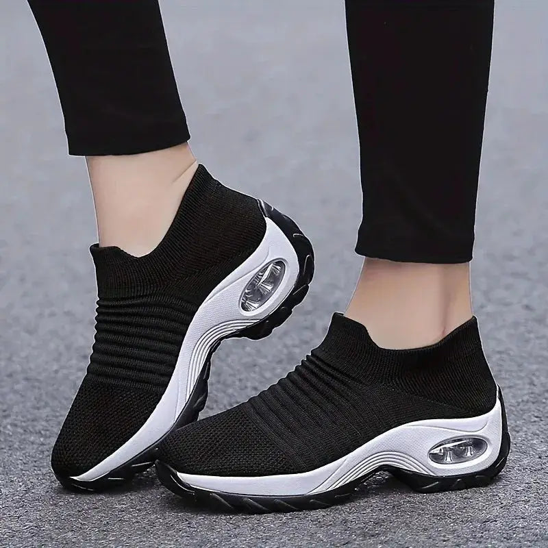 Black women's slip-on sock sneakers with white air cushion sole, breathable mesh fabric ideal for walking, workouts or everyday casual use.