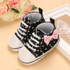 Black baby sneakers with pink bow