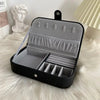 Black portable jewelry box with empty compartments.