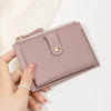 Minimalist short wallet in light pink held in hand