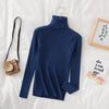 Navy blue women's turtleneck sweater on bed