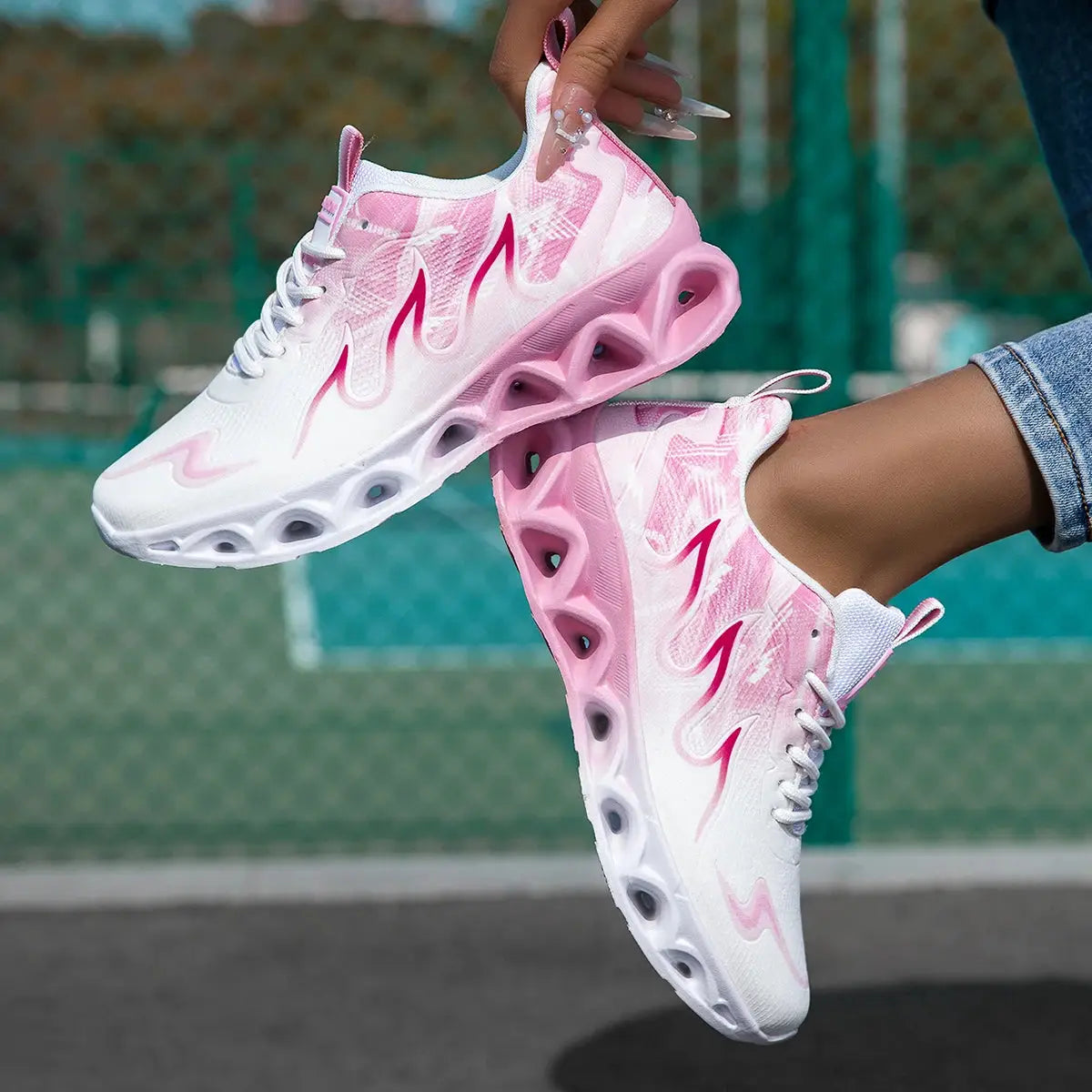 Stylish women's running sneakers featuring pink flame graphics, soft blade sole, and breathable mesh for comfort and performance.