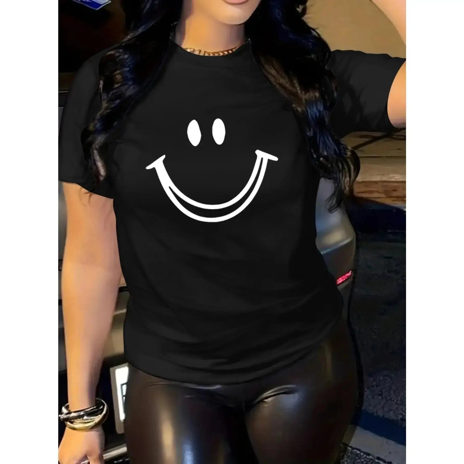 Women’s black T-shirt with joyful face print styled with black leggings, made of soft cotton with a casual crew neck fit.