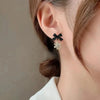 Woman wearing black bow knot snowflake dangle earring