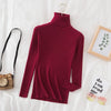 Burgundy women's turtleneck sweater on bed