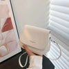 White vintage PU leather crossbody bag on black table