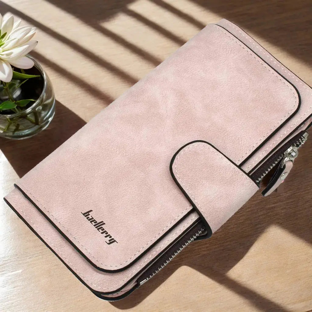 Light pink women's long trifold wallet with snap closure and zippered pocket, ideal for organizing cards and phone.