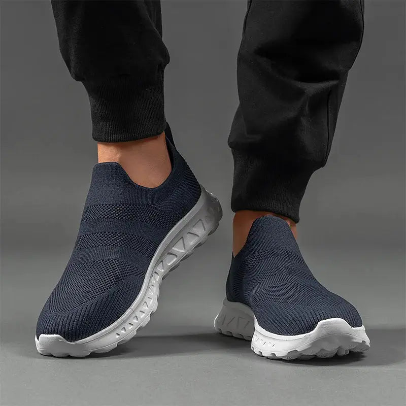 Men’s slip-on sneakers in navy with breathable mesh and white sole, ideal for running, walking, or casual outdoor wear.