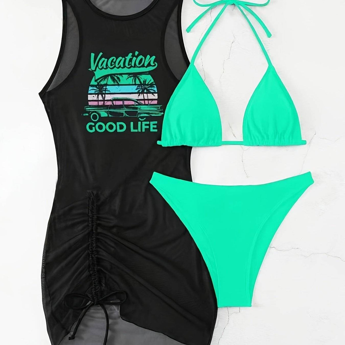 Flat lay of neon green Women’s Knot-Tie Bikini Set with crisscross tummy control and black mesh dress featuring 'Vacation Good Life' graphic.