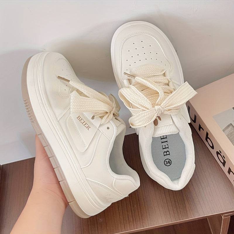 White casual women’s sneakers with thick laces and cushioned sole, offering all-day comfort and a stylish minimalist look.