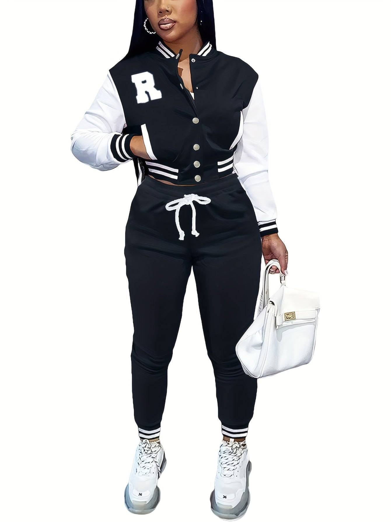 Black and white women’s 2-piece athletic outfit with crop top varsity jacket and drawstring pants, offering a bold and sporty look.