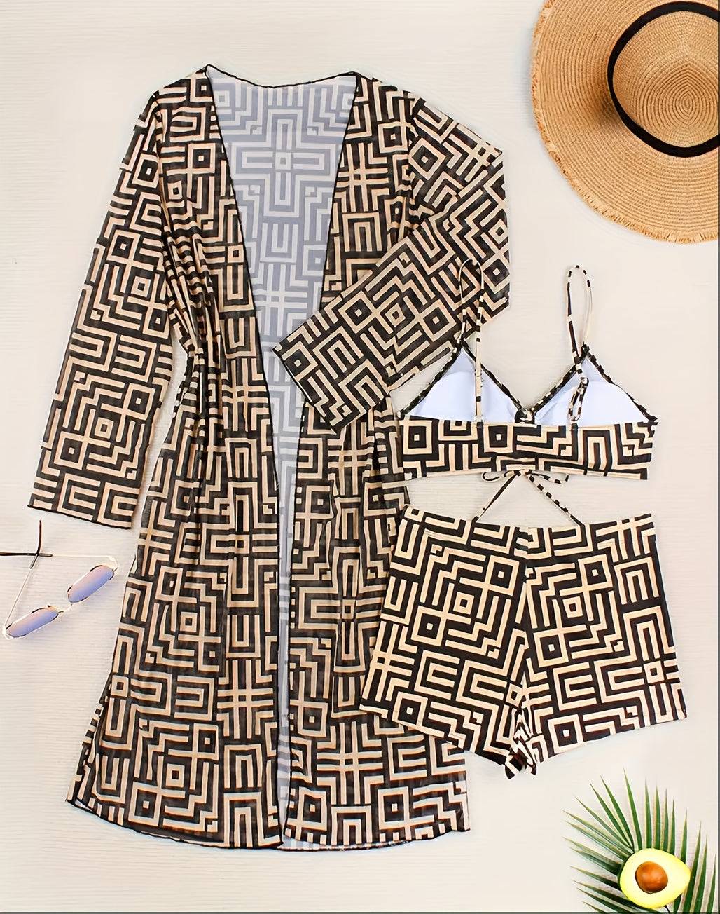 Flat lay of 3pcs Women’s One-Shoulder Swimsuit Set including ruched bikini top, matching shorts, and long sheer cover-up with geometric vacation print.