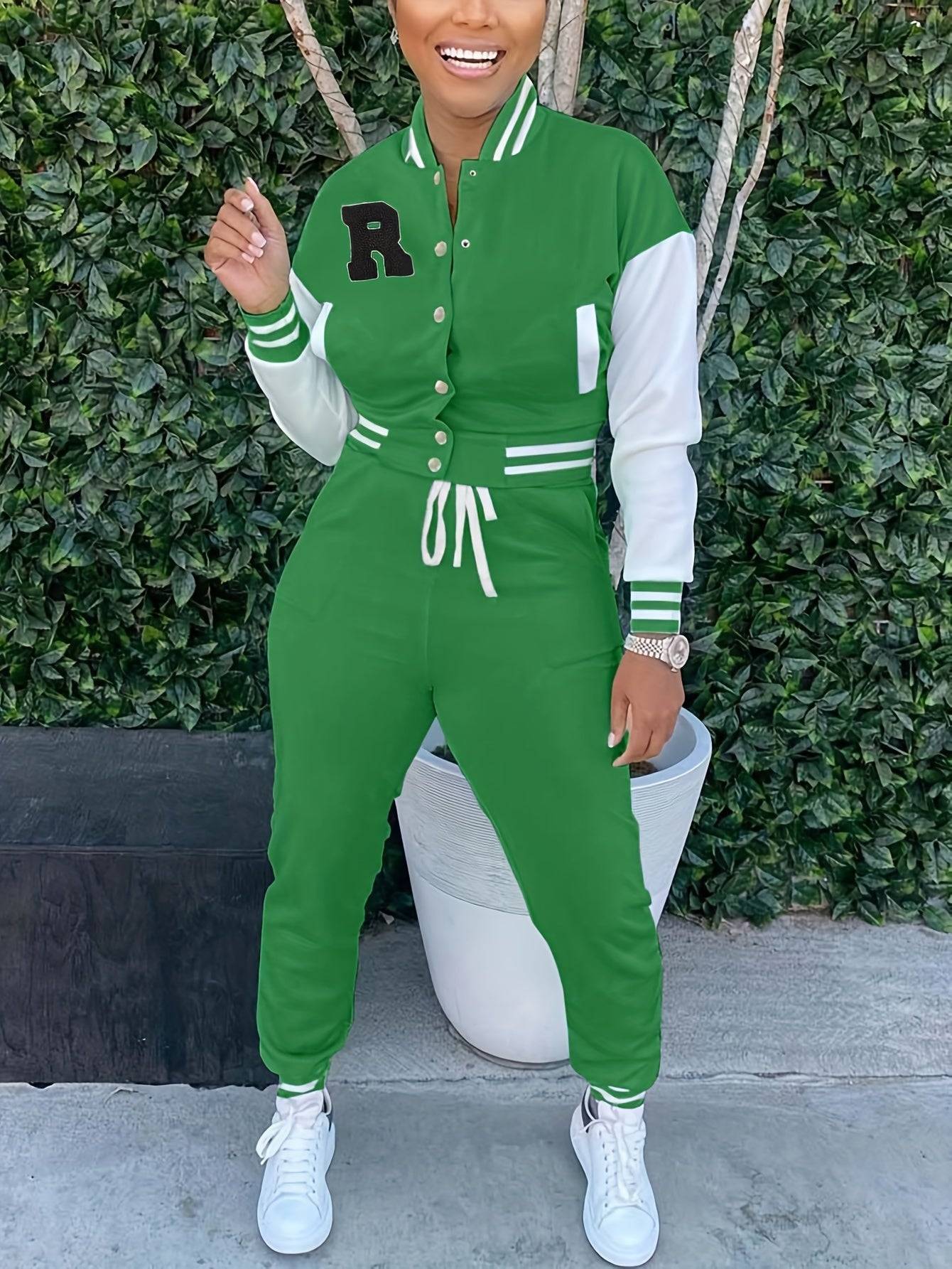 Green women’s 2-piece sportswear outfit with varsity jacket and joggers, styled with white sneakers for a casual athletic vibe.