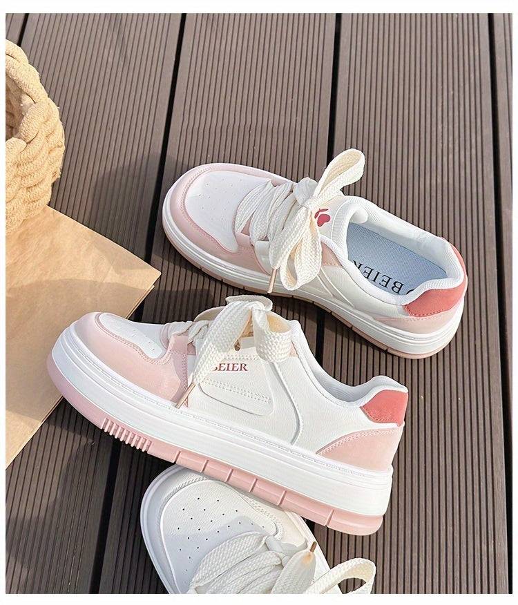 Top view of pink and white women’s sneakers with round toe and thick laces, offering a trendy and supportive fit.